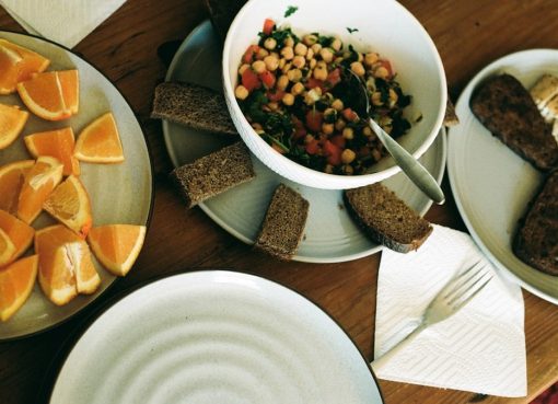 A wooden table topped with plates and bowls of food